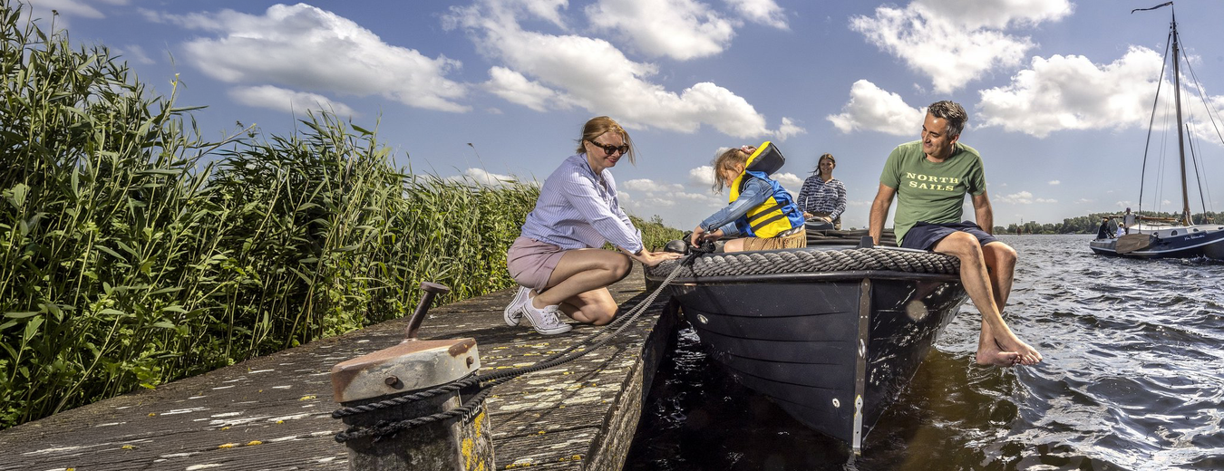 Gezin met een sloep aan de steiger