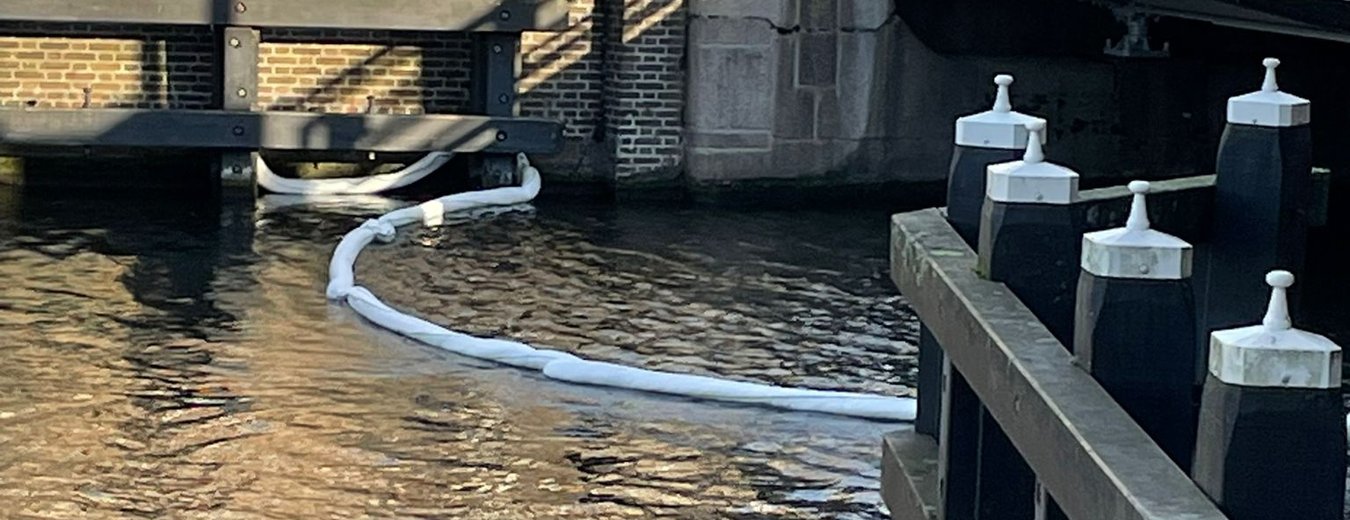 Olieboom op het water in de gracht Leiden