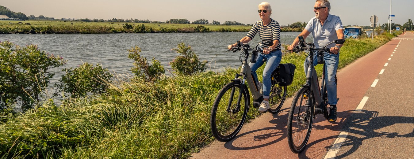 Twee fietsers fietsen langs de ringvaart